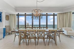 a dining room with a table and chairs and a chandelier at The Oasis at Orange Beach 2411 (Phoenix West II) in Orange Beach