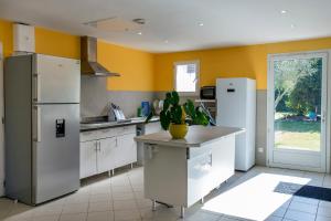 a kitchen with white appliances and yellow walls at Locatlantique in Aytré