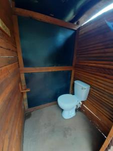 a bathroom with a toilet in a room with wooden walls at Impala trailor tent in Thabazimbi