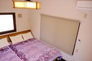 a small room with a bed and a window at Forest-inn Kasama in Kasama