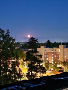 a view of a city at night with the moon in the sky at Big room with balcony in a shared apartment in the center of Kerava in Kerava