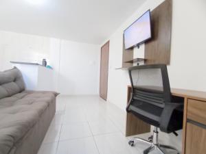 a room with a couch and a desk with a chair at Apartamento Aconchegante in Brasilia