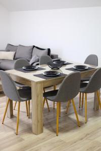 mesa de comedor con sillas y sofá en Studio Petra en Soko Banja