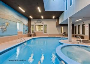 a swimming pool in a hotel room with a large pool at Magog Waterfront Condo in Magog-Orford