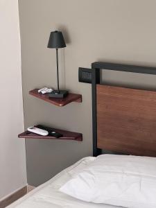 a bedroom with a bed with wooden shelves and a lamp at Medusa Duomo Guest House in Naples