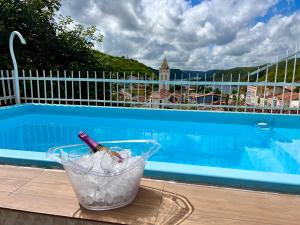 una bottiglia di vino in un secchio accanto alla piscina di Pousada Lua Rosa a Piranhas