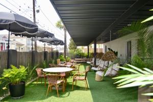 un patio esterno con tavoli, sedie e ombrelloni di Marsh Hotel a New Orleans