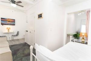 a white bedroom with a bed and a desk at Studio Bungalow in the Heart of Normal Heights in San Diego