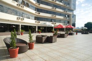 a building with tables and potted plants in front of it at Hotel Nacional Inn Campinas Trevo in Campinas