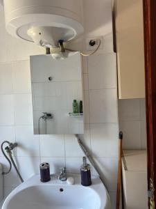 uma casa de banho com um lavatório e um espelho em Dea Apartment em Berat