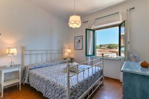 a bedroom with a bed and a large window at Villa Le Tre Palme in Porto Azzurro