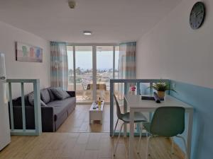 a living room with a table and a couch at Casa Bonita Vista - Playa del Inglés in San Bartolomé de Tirajana
