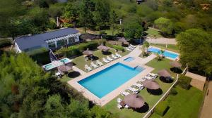 una vista aérea de una piscina con sillas y sombrillas en Aldea de los Pajaros en Villa General Belgrano