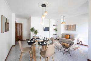 a living room with a table and chairs and a couch at Braga 3BR Wonder by LovelyStay in Braga