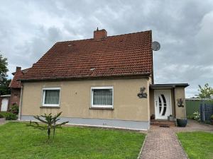 uma casa com um telhado castanho e um jardim verde em Ferienhaus - a90588 em Grevesmühlen