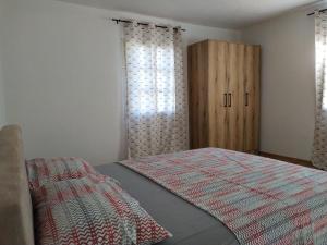 een slaapkamer met een bed en een houten kast bij Olive House in Petrovac na Moru