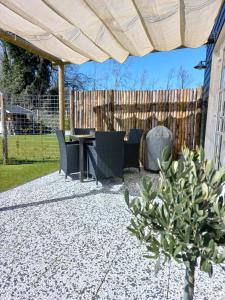 a patio with a table and chairs and a fence at B&B Ouddorps Huisje in Ouddorp