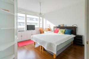 Un dormitorio con una cama con almohadas de colores. en White House 61m2 Alppila Helsinki en Helsinki