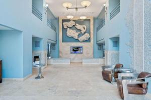 a lobby with a fireplace and a painting on the wall at Lovely Sandestin Resort Studio with Balcony and Sunset View in Destin