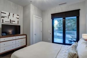 a bedroom with a bed and a tv and a window at Downtown Condo City Center in Asheville