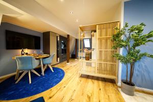 een woonkamer met een tafel en een blauw tapijt bij EDLER WOHNRAUM Modernes Vorstadtstudio mit Kaffeevollautomat, Garten & Netflix in Zwickau