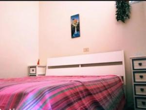 a bedroom with a bed and a picture on the wall at L'angolo della felicità in Marina di Montenero
