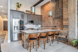 a kitchen with a counter with stools and a sink at Exceptional Downtown Condo in Asheville