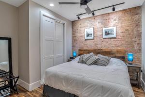 a bedroom with a bed and a brick wall at Exceptional Downtown Condo in Asheville