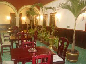 a restaurant with tables and chairs and palm trees at Hotel Maya Ah Kim Pech in Campeche