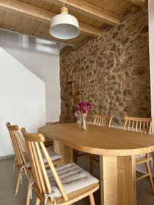 a wooden table with chairs and a vase of flowers at Ca Tono Casa Rural in Les Coves de Vinroma