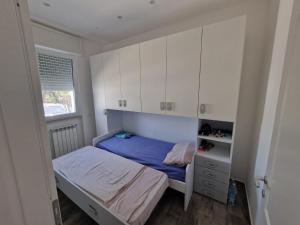 ein kleines Schlafzimmer mit einem Bett und weißen Schränken in der Unterkunft the suite on the beach in Torvaianica