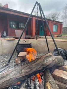 a fire pit with a piece of wood and a chain at Casa de campo in Mercedes