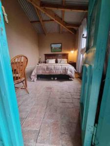 a bedroom with a bed and a chair in a room at Casa de campo in Mercedes