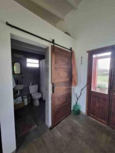 a bathroom with a toilet and a wooden door at Casa de campo in Mercedes