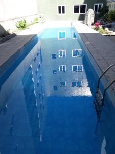 uma piscina com água azul em frente a um edifício em Hotel Du Lac Macaé em Macaé