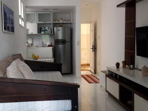a kitchen with a refrigerator and a living room at Loft aconchegante no Leblon in Rio de Janeiro