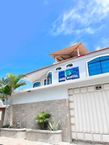 une maison blanche avec un garage dans l'établissement Reef Hostel Manta, à Manta