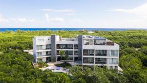 an aerial view of a building with the ocean in the background at Luxurious Apartments With BBQ Pool Garden Jungle View in Akumal