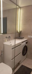 La salle de bains est pourvue d'un lave-linge et d'un lavabo. dans l'établissement New and comfortable apartments, à Oujhorod