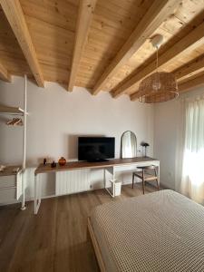 a bedroom with a desk with a television and a bed at Ca Tono Casa Rural in Les Coves de Vinroma