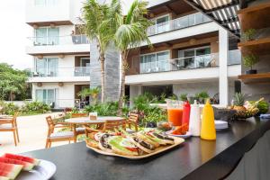 una mesa con una bandeja de comida y bebidas. en Luxurious Apartments With BBQ Pool Garden Jungle View en Akumal