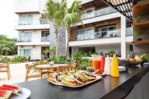 una mesa con una bandeja de comida y bebidas. en Luxurious Apartments With BBQ Pool Garden Jungle View, en Akumal