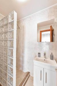 a white bathroom with a sink and a mirror at Chania Getaway Pool*Parking*A/C in Chania