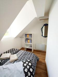 a bedroom with a black and white bed in a attic at Appartements cosy BELFORT in Belfort