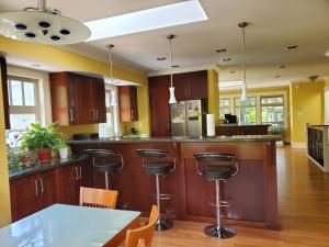 a kitchen with wooden cabinets and a table with chairs at Elegant, Sunny Modern Home with Skylights - Kitsilano, Vancouver in Vancouver +9 photos