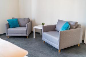 two chairs and a table in a room at Ferienwohnung Nadine Petschler in Obereisenheim
