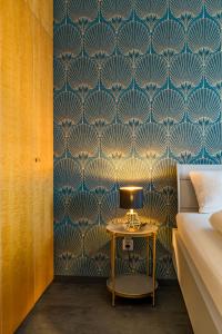 a bedroom with blue and gold wallpaper and a table at Ferienwohnung Nadine Petschler in Obereisenheim
