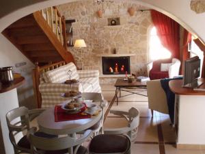 a living room with a table and a fireplace at Rock House's Villa Melody in Plataniás