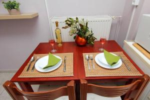 a wooden table with two white plates and wine glasses at Κεντρικό κομψό ήσυχο στούντιο. in Ámfissa