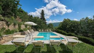 una piscina con sedie a sdraio e una piscina di La Canonica a Bagni di Lucca
